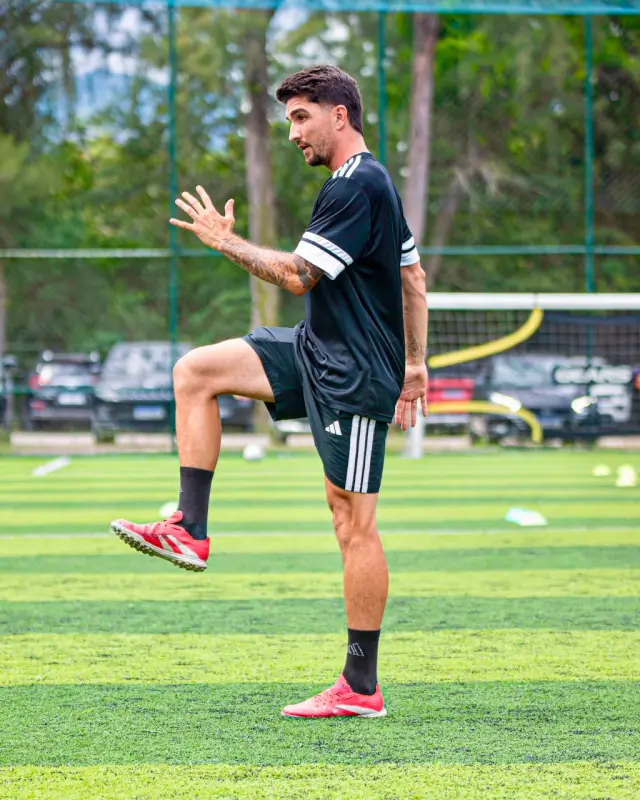 Lucas executando exercício de elevação de joelho no gramado